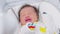 Crying Newborn baby boy lying on white bed at home.Infant baby screaming very hungry or stomach pain.Tired baby crying concept