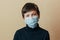 A crying teenager in a face mask looks at the camera and worries about the consequences of the coronavirus epidemic. Depression du