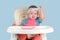 A crying toddler of 12-17 months refuses to eat cottage cheese while sitting on a baby feeding chair