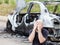 Crying upset man at arson fire burnt car vehicle junk