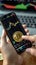 Cryptocurrency concept Hand holding Bitcoin, smartphone displays stock chart