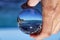Crystal ball with recletion of Aphrodite bath beach at morning light. Glass/Lens ball holding in hand with blue, clear sea. Sky is