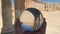 Crystal ball reflection against ancient ruins of roman city, columns, hand holding