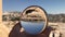 Crystal ball reflection against ancient ruins of roman city, columns, hand holding