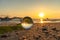 A crystal ball rests on the sandy pebbles of Kalim Beach.