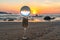 A crystal ball rests on the sandy pebbles of Kalim Beach.