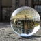 Crystal ball on a rough stone slab with the inverted spherically distorted image of a building in the city center
