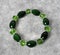 Crystal bracelet green color with silver accents on the abstract background