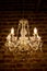 Crystal chandelier, antique lamp on the background of the brown brick wall.