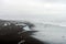 Crystal clear and blue ice chunks washes up on the black lava sand