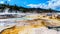 Crystal Clear Blue Water and Brown Bacteria Mats created by cyanobacteria in the water of the Travertine Terraces formed by Geyser