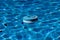 Crystal clear Bright blue chlorine distributor floating in a swimming pool