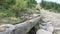 Crystal Clear Fresh Mountain Water Falling from Wooden Pipe. Hiking Adventure.