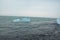 Crystal clear ice chunks floating on the waves of Diamond beach in Fellsfjara,Jokulsarlon on Iceland