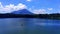 a crystal clear lake Ranu Klakah, Lumajang with a majestic mountain in the background.