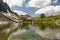 Crystal clear water of alpine lake Lache in Tannheimer high valley with mountain refuge Landsberger Hut, Tyrol, Austria