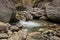 Crystal clear water of a cold mountain creek at rocky terrain of Samaria gorge, south west part of Crete island