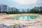 Crystal clear water at sand quarry pond. Clay quarry, muddy shore surrounded by trees outdoors