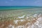 Crystal clear water with small waves, azure sea in background. U