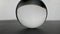 Crystal glass ball sphere transparent rolling on grey gradient background.