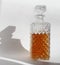 Crystal glass shaped straight bottle with whiskey cognac on a white background