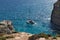 Crystal lagoon of Comino island with catamaran. Scenic summer tropical landscape. Clear bay with cliffs and transparent