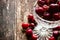 Crystal vase with rustic cherry with water drops on a wooden table