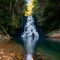 Crystalclear waterfall descends gracefully amidst tranquil woodland