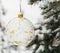 Crystalline Christmas tree ball on a snow-covered tree branch