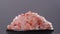 Crystals of pink Himalayan salt rotate in slow motion