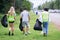 CSR activity. Corporate Social Responsibility. Three volunteers, Asian male, female and Caucasian are helping to pick up waste by