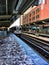 CTA`s pink line train entering the station at Clinton/Adams stop in Downtown Chicago Loop during snowy winter day.