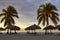 Cuba, 2014. A Caribbean beach resort with palm trees, shades and beach chairs.