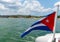 Cuba flag waving on boat at sea near Cuban coastline
