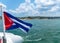 Cuba flag waving on boat at sea near Cuban coastline