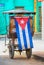 Cuban cycle taxi with Cuban flag,Cycle taxi in Old Havana, Cuba. Tricycle made into a taxi.