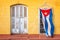 Cuban flag hanging at the window of a colorful house in a street of Trinidad Cuba