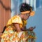 Cuban flower girl, woman in typical costume, resting and looking at mobile phone, Havana, Habana Vieja, Cuba