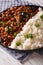 Cuban food: Picadillo with a side dish of rice close-up. Vertical