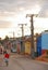 A cuban man riding cycling on a bicycle along the colourful houses & electricity poles in Trinidad, Cuba