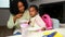 Cuban mother feeding spaghetti with sausages to her toddler daughter.