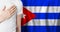 Cuban person with hand on heart on the background of Cuba flag. Patriotism, country, national, pride concept