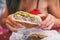 Cuban sandwich closeup woman holding local food at typical cafe outside. Pressed cuban bread with roasted pork, salami