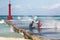 Cuban teenagers having fun sitting on pier of a lighthouse under spray of sea