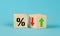 Cube block with percentage symbol icon. Interest rate financial and mortgage rates concept. Wood cube change arrow down