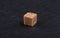 Cube of brown refined cane sugar on a stone background.