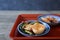 Cubed Radish Kimchi and turnip kimchi on a red tray isolated on a wooden background