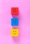 Cubes with cute faces depicting human emotions: anger, sadness and happiness