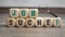 Cubes or dice with magnifier or magnifying glass and job search on wooden background
