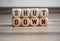 Cubes and dice with word shutdown and lockdown on wooden background